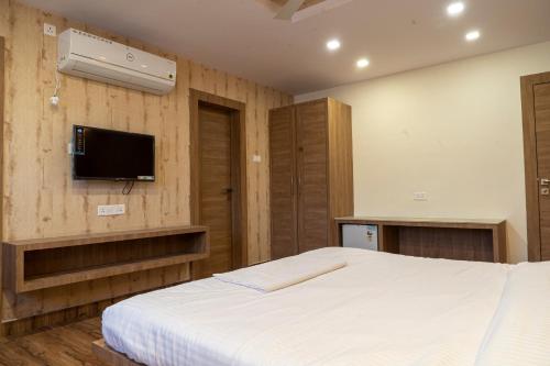 a bedroom with a bed and a flat screen tv at Hotel Sohrai Inn in Rānchī