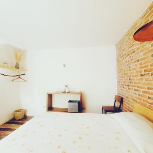 a bedroom with a bed and a brick wall at Hoja Santa Posada in Cholula