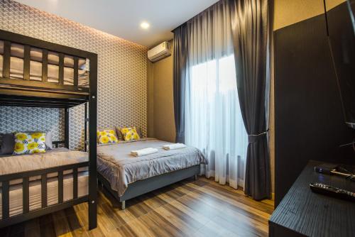 a bedroom with two bunk beds and a window at Laboon Pool Villa บ้านพักส่วนตัวพร้อมสระว่ายน้ำ ชะอำ in Nikhom Sang Ton Eng Khuan Phet