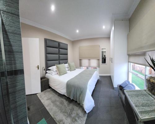 Un dormitorio con una cama grande y una ventana grande. en Bon Game Reserve, en Blandʼs Drift