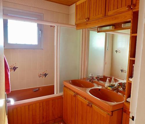 La salle de bains est pourvue de 2 lavabos, d'une baignoire et d'une fenêtre. dans l'établissement Le Bonheur en Vacances ! :), à Lacanau