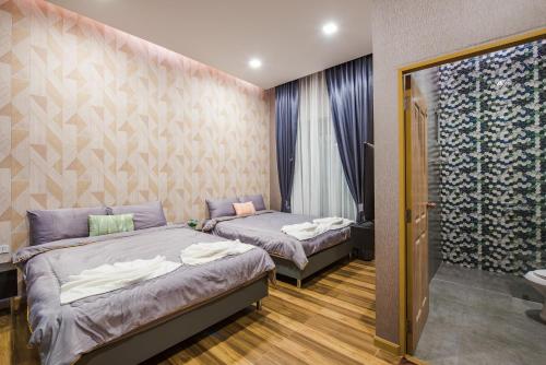 a bedroom with two beds and a bathroom at Laboon Pool Villa บ้านพักส่วนตัวพร้อมสระว่ายน้ำ ชะอำ in Nikhom Sang Ton Eng Khuan Phet