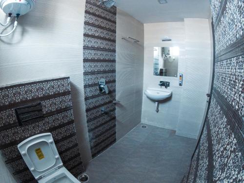 a bathroom with a toilet and a sink at Hotel Sohrai Inn in Rānchī