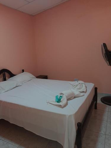 Un dormitorio con una cama con toallas blancas. en MI REFUGIO en Belén