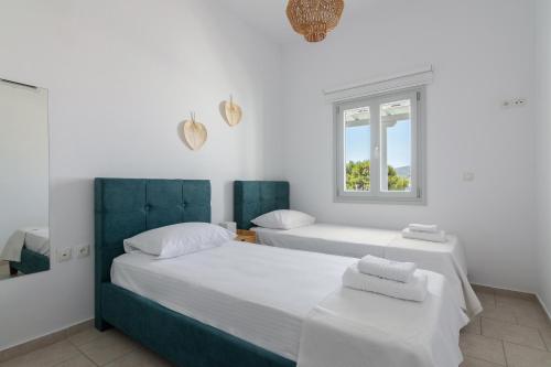 two beds in a white room with a window at Nice And Spacious Apartment In Paros in Naousa