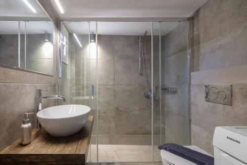 a bathroom with a sink and a glass shower at Nice And Spacious Apartment In Paros in Naousa