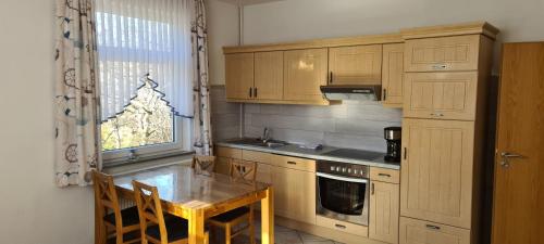 a kitchen with wooden cabinets and a table and a window at Seevilla Wietjes Whg 2 in Baltrum