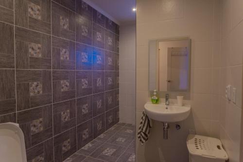 a bathroom with a sink and a toilet at Lovely Caribbean family villa with private pool in Willemstad