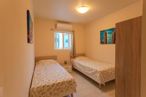 1 Schlafzimmer mit 2 Betten und einem Fenster in der Unterkunft Lovely Caribbean family villa with private pool in Willemstad