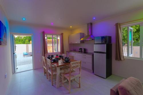 a kitchen with a table with chairs and a refrigerator at Lovely Caribbean family villa with private pool in Willemstad