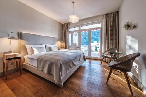 Schlafzimmer mit einem Bett, einem Tisch und Stühlen in der Unterkunft Hotel Edelweiss in Davos