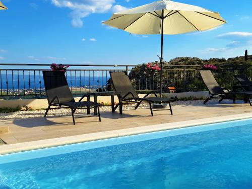 two chairs and an umbrella next to a swimming pool at Holiday House Above with pool and summer kitchen in Klis