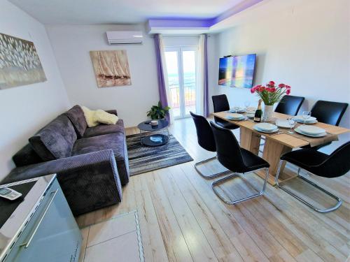 a living room with a couch and a table with chairs at Holiday House Above with pool and summer kitchen in Klis