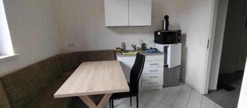 a small kitchen with a wooden table and a refrigerator at zu den blauen Schwertern in Meißen