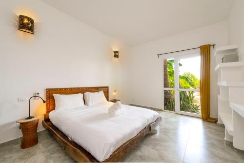 - une chambre avec un lit et une grande fenêtre dans l'établissement Surfescape Zanzibar, à Kiwengwa
