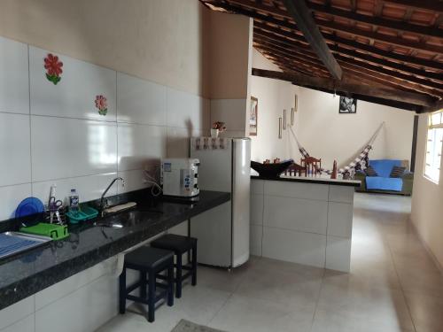 a kitchen with a refrigerator and a counter with stools at Casa Colonial no Centro in Carolina