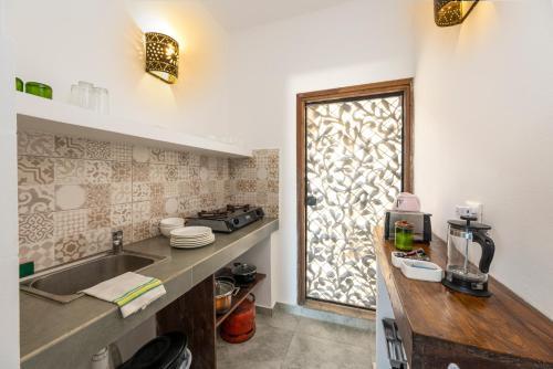 uma cozinha com um lavatório e um balcão com uma janela em Surfescape Zanzibar em Kiwengwa