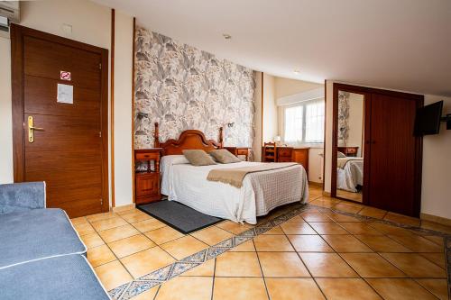 1 dormitorio con 1 cama y 1 sofá en Pensión Zumardi, en Deba