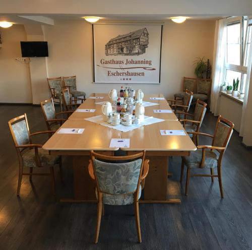 una sala de conferencias con una gran mesa de madera y sillas en Gasthaus Johanning eK en Uslar
