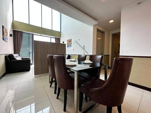 a dining room with a table and leather chairs at PD D'Wharf Duplex 3BR - Full Seaview (Up To 12 Pax) in Port Dickson