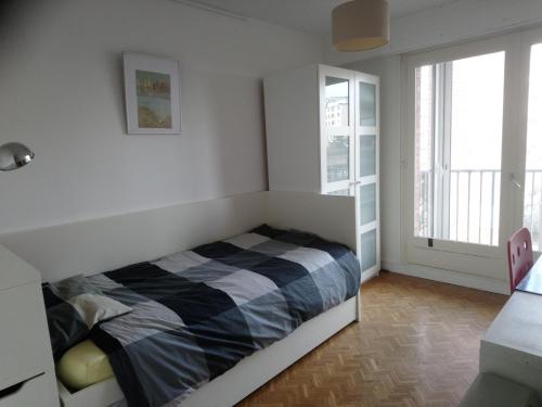 ein Schlafzimmer mit einem Bett in einem Zimmer mit Fenstern in der Unterkunft OPALINE T3 lumineux avec patio et parking privé in Dunkerque