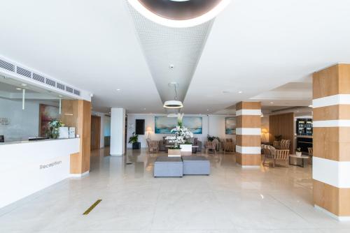 a lobby of a hospital with chairs and tables at Evalena Beach Hotel in Protaras
