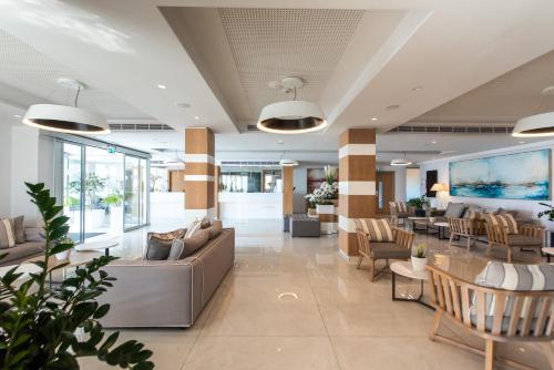 a lobby of a hotel with couches and chairs at Evalena Beach Hotel in Protaras