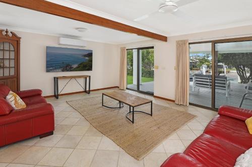 a living room with a red couch and a table at Fantastic Buddina Duplex in Buddina