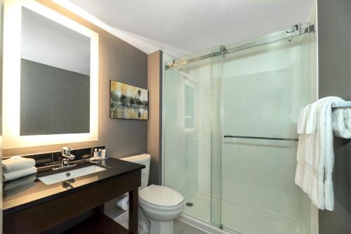 a bathroom with a shower and a toilet and a sink at Comfort Inn Hamilton/Stoney Creek in Hamilton