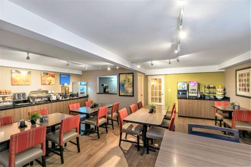 a restaurant with tables and chairs and a counter at Comfort Inn in Hamilton