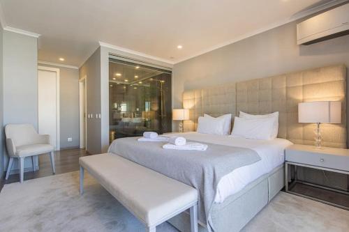 1 dormitorio con 1 cama blanca grande y 1 silla en Seaview Luxury Apartment, en Cascais