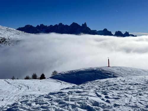 a tent on top of a snow covered mountain with clouds at EMARGHE, CASA A MOENA in Moena