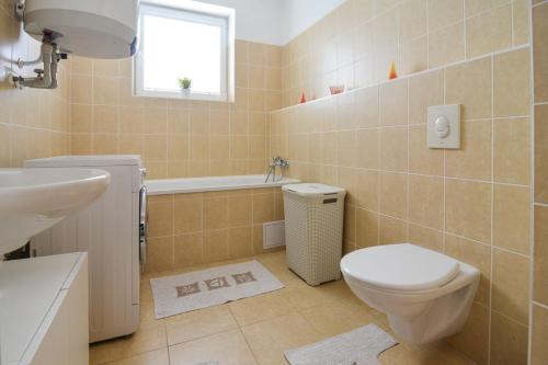 een badkamer met een toilet, een wastafel en een bad bij Apartman U Kostela in Deštné v Orlických horách