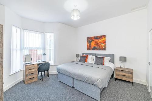 Habitación blanca con cama y escritorio en 3 Bedroom Holiday Home within Kensington en Liverpool