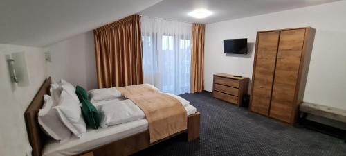 a bedroom with a bed and a cabinet and a television at Casa Pe Vale in Râşnov