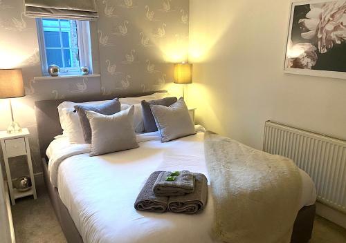 a bedroom with a white bed with a tray on it at The Lodge Chester - luxury apartment for two, with free parking! in Hough Green