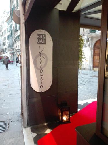 a sign on the side of a building with a candle at Old Town Guest House in Genova
