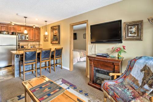 a living room with a television and a kitchen with a table at Ski-InandSki-Out Copper Mountain Condo with Balcony! in Copper Mountain