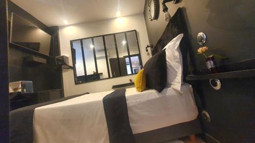 une chambre avec un grand lit blanc avec un miroir dans l'établissement Côté mer Marseille Vieux-Port 