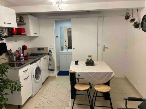 une cuisine avec une table et une machine à laver dans l'établissement Le cocon Balnéo, à Sens