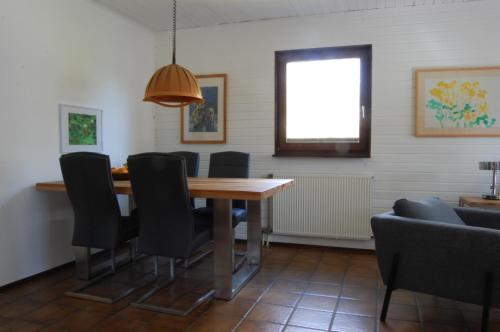 a dining room with a wooden table and black chairs at Bon Air in Thalfang