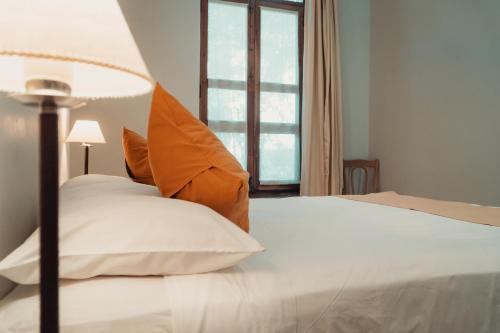 1 dormitorio con 1 cama blanca y ventana en Vieja Posada Hotel Histórico en Cafayate