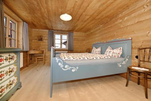 Un dormitorio con una cama en una cabaña de madera. en s'batlogg8, en Schruns