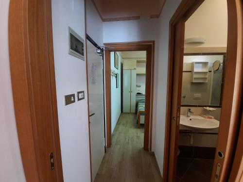 - un couloir menant à une salle de bains pourvue d'un lavabo dans l'établissement Hotel Colorado, à Rimini