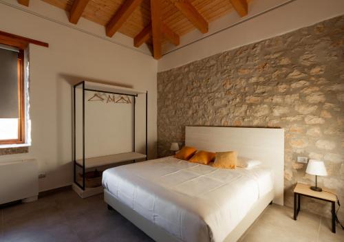 una camera con letto e parete in pietra di Tenuta San Martino a Nusco