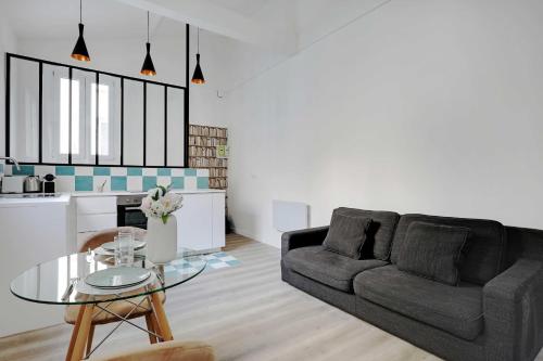 un salon avec un canapé et une table en verre dans l'établissement Intimate apartment - 1BR-4P - Javel, à Paris