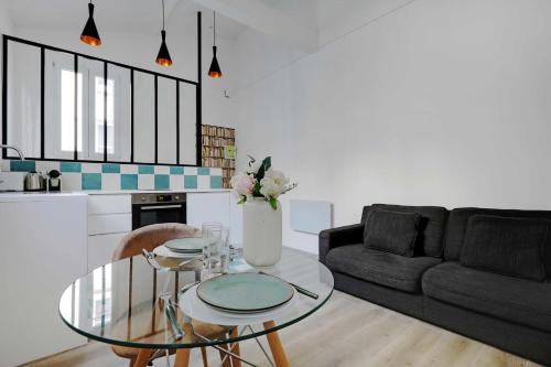 un salon avec une table en verre et un canapé dans l'établissement Intimate apartment - 1BR-4P - Javel, à Paris