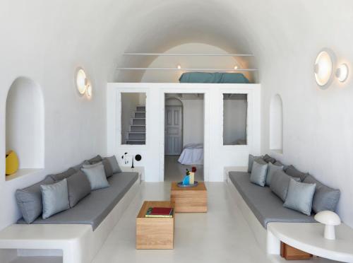 a living room with two couches and a table at Inspire Santorini Luxury Villas in Fira