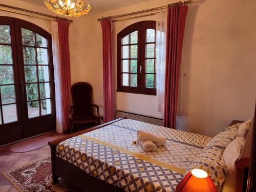 a bedroom with a bed and two windows at Villa avec piscine privée in Allauch