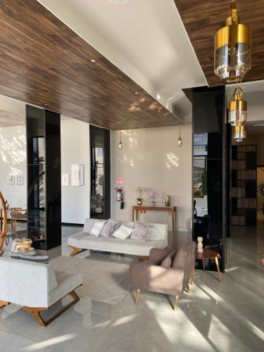 a bedroom with a bed and a couch and chairs at ZEGEN HOTELS LagosdeMoreno in Lagos de Moreno